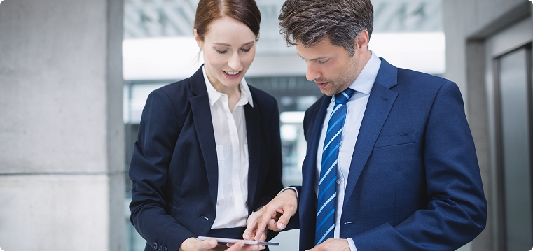 Colleagues discussing work on a tablet